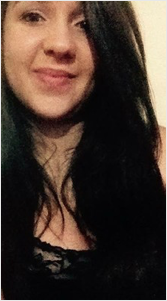 Aluna Mariana Trevisan. Mulher jovem de pele clara, olhos preto, cabelo comprido de cor castanho escuro, usa uma blusa preta e sorri.